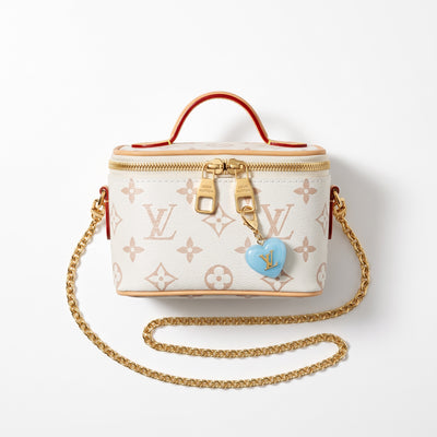 Louis Vuitton cream monogram vanity case with gold chain and blue heart charm