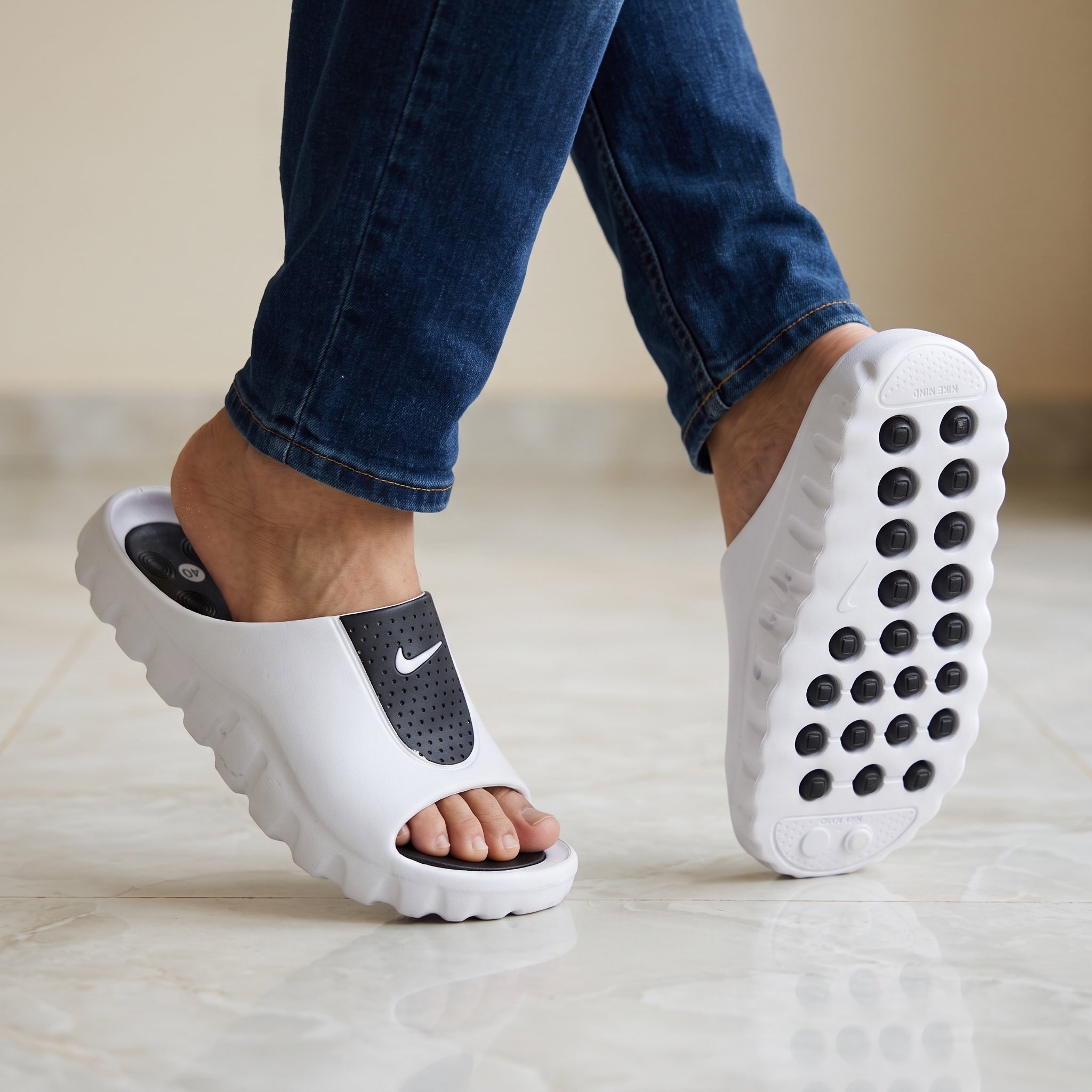 white Nike slip-on slide with black perforated strap and chunky textured sole