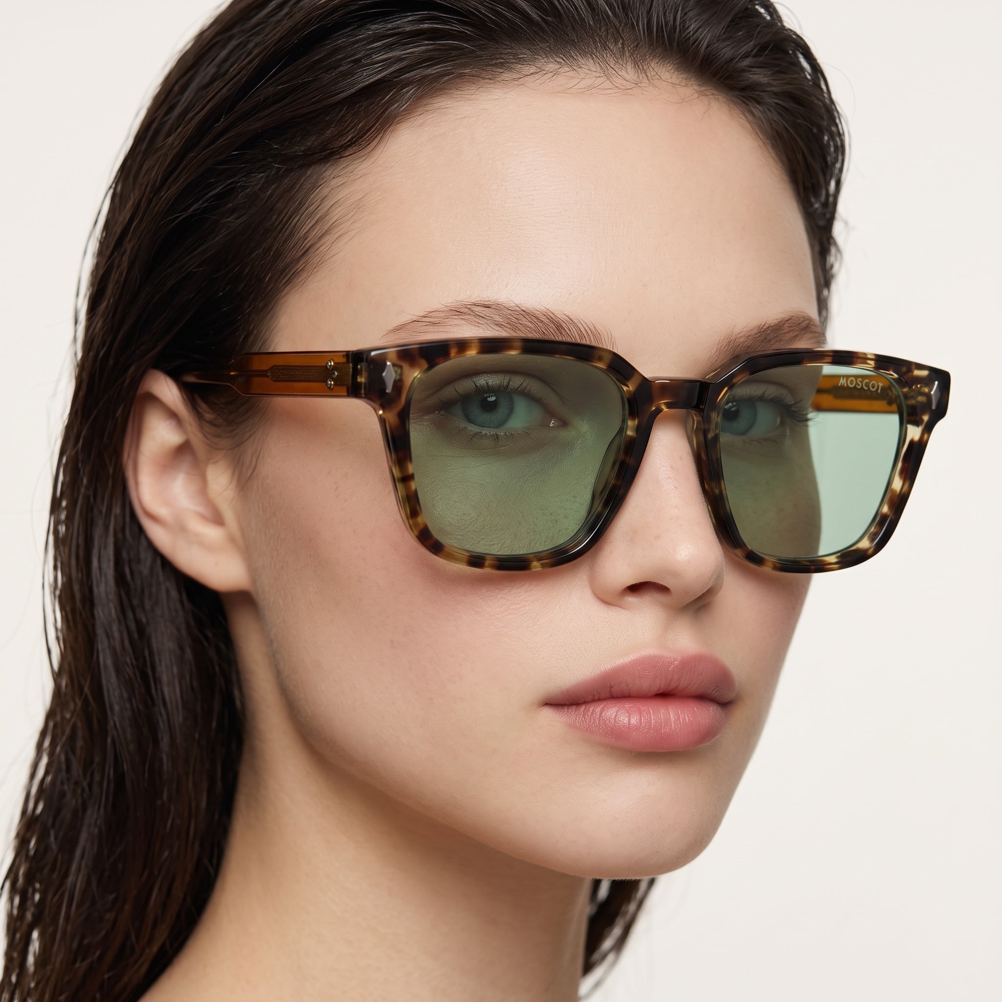 Close-up of Moscot tortoise-pattern square sunglasses with green lenses