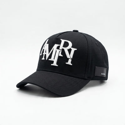 Black Amiri baseball cap with white embroidered logo and side patch.