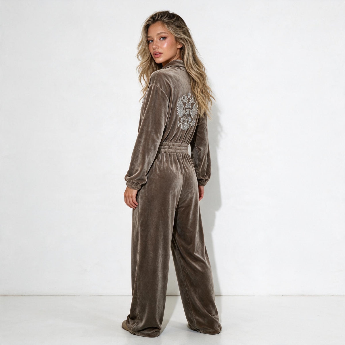 taupe velour jumpsuit with half zip collar, elastic waist, wide legs and embellished crest on chest and back