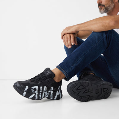 Black Amiri chunky sneakers with white painted graffiti on sole and upper
