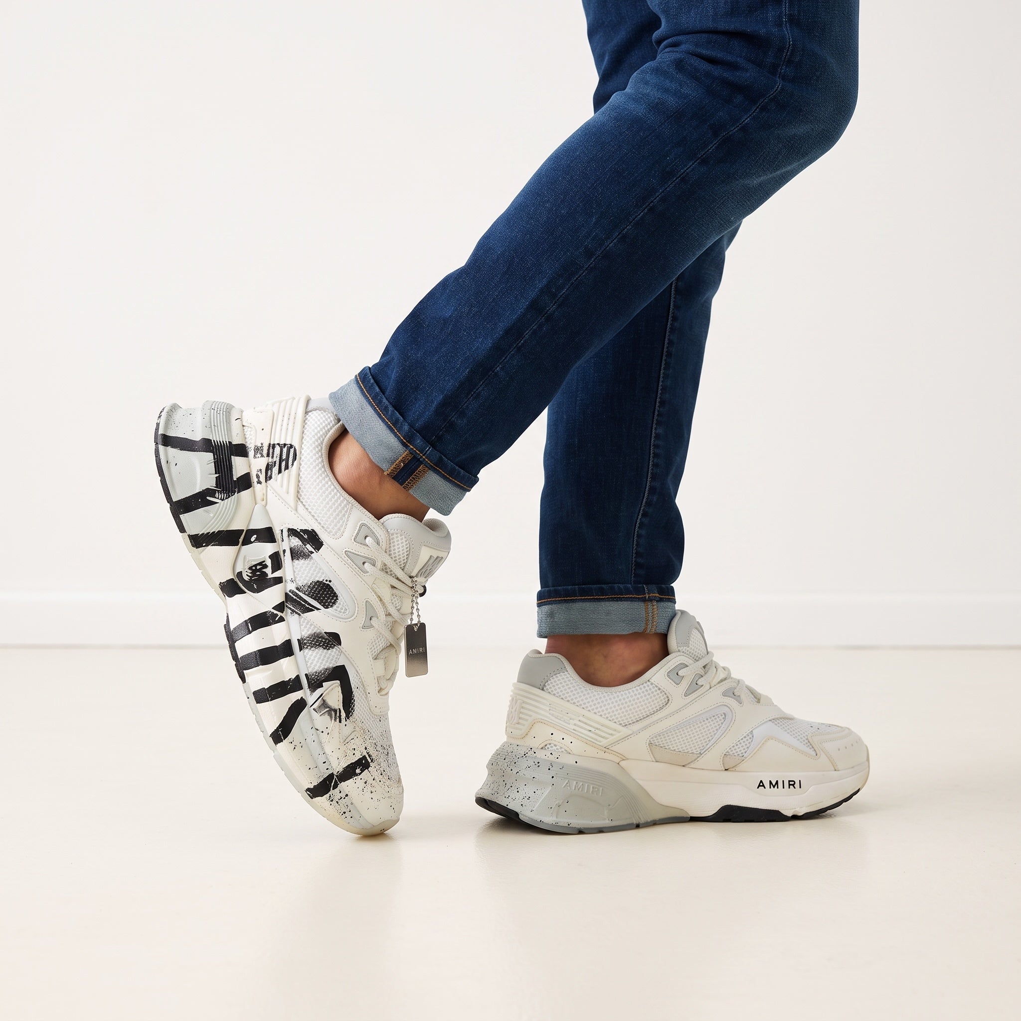 Amiri white chunky sneaker with black graffiti print and metal tag
