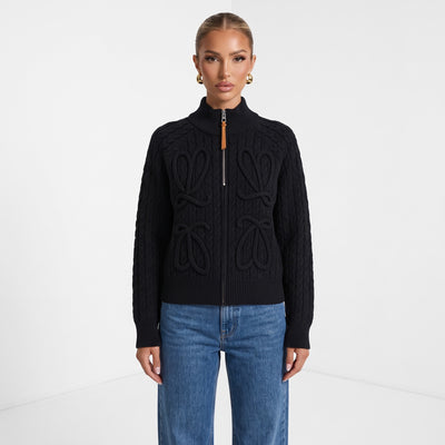 black cable knit zip sweater with tan leather zipper pull and braided loop details