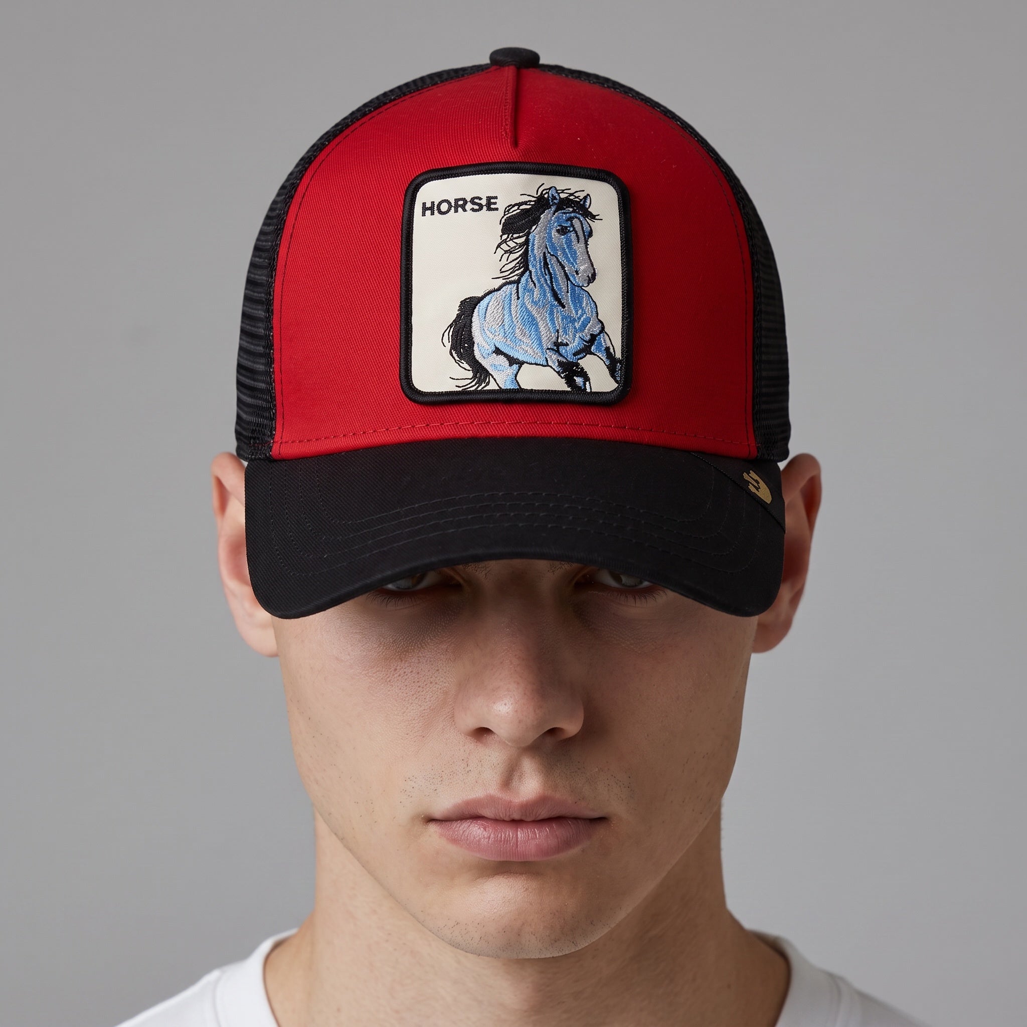 Red and black Goorin Bros trucker cap with embroidered horse patch on front