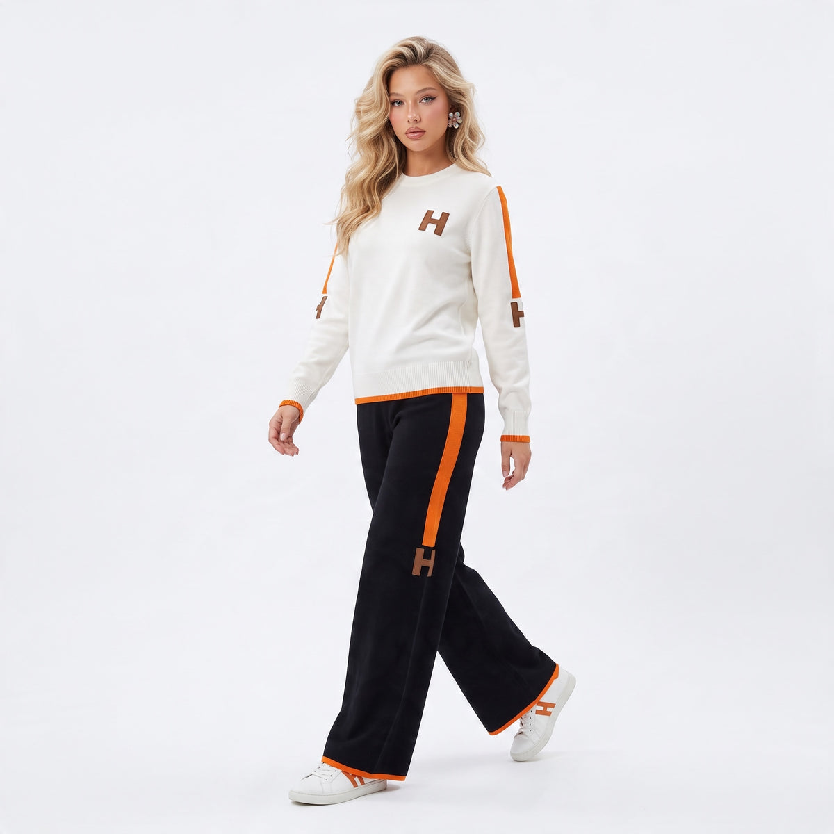 Ivory crewneck sweater with orange trim and brown H logos on chest and sleeves