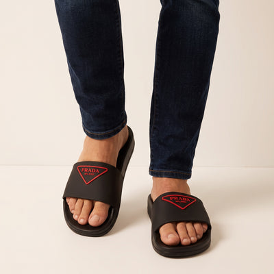 Black Prada rubber slides with red triangular logo on strap