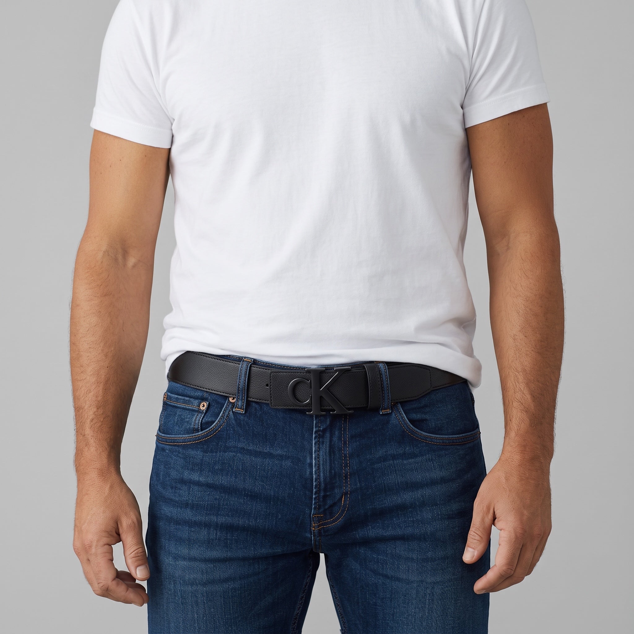 Black Calvin Klein belt with CK logo buckle worn with jeans and white tee