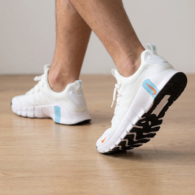 white Nike Free trainer with blue heel accent and orange swoosh