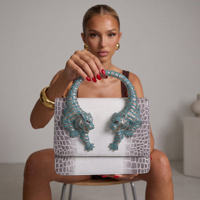 white and grey croc-print top-handle bag with turquoise crystal tiger-head hardware