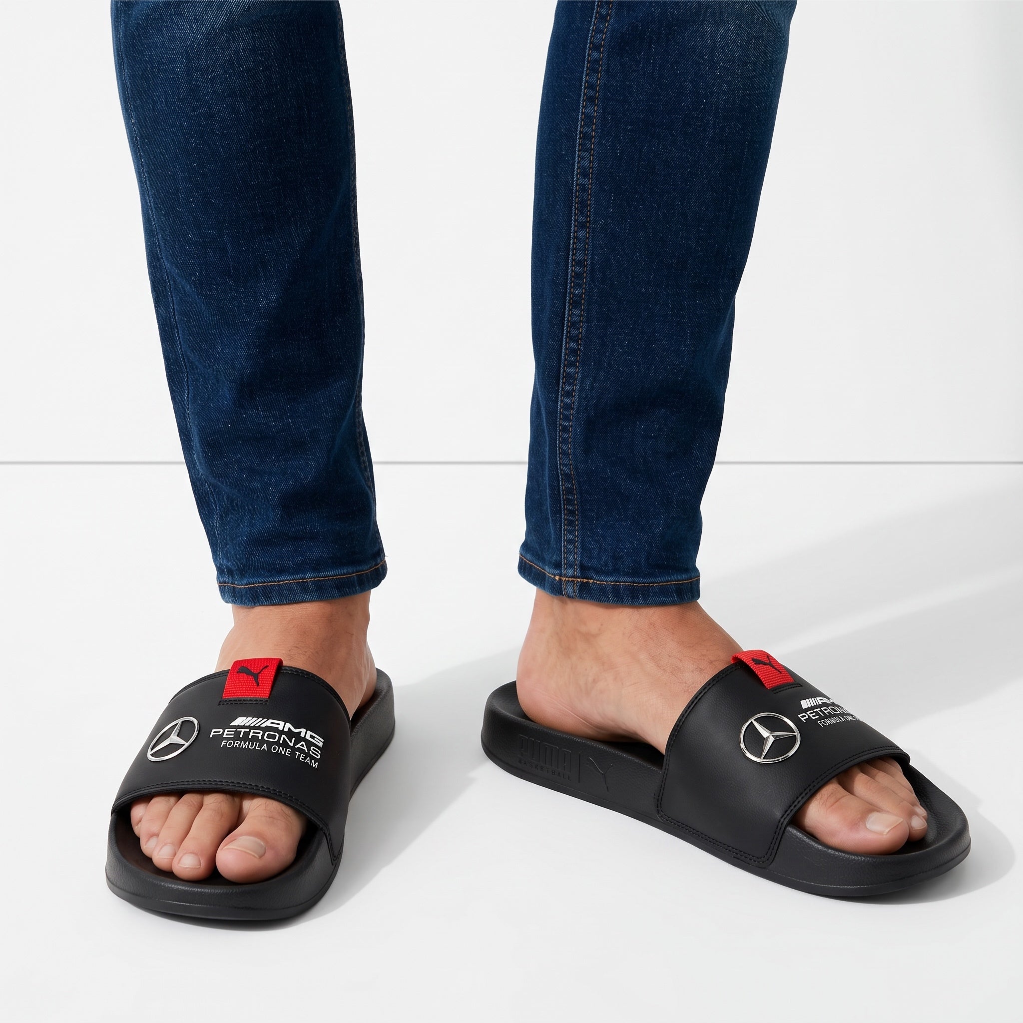 black Puma AMG Petronas branded slide sandals with red pull tab and Mercedes emblem