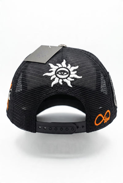 black trucker cap with multiple embroidered patches and mesh back
