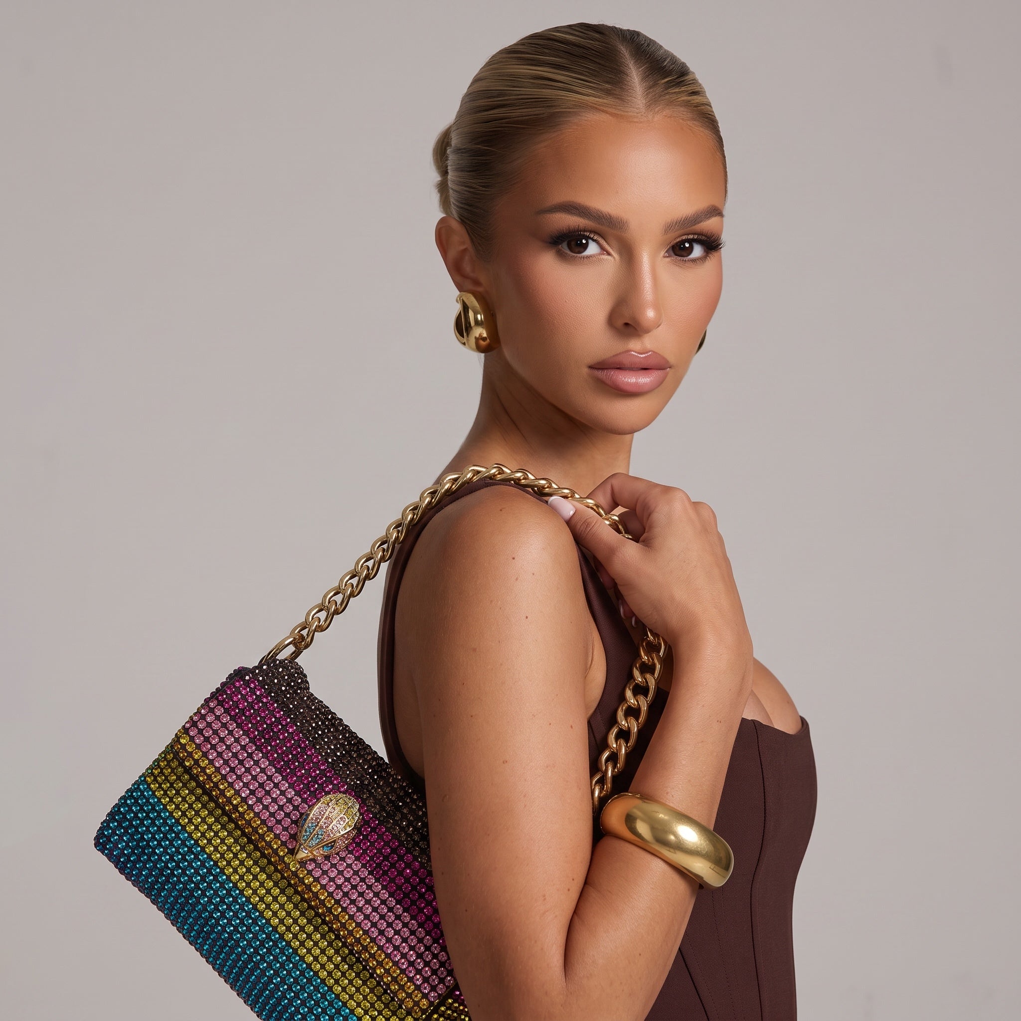 Rainbow crystal-studded shoulder bag with gold chain strap and decorative clasp