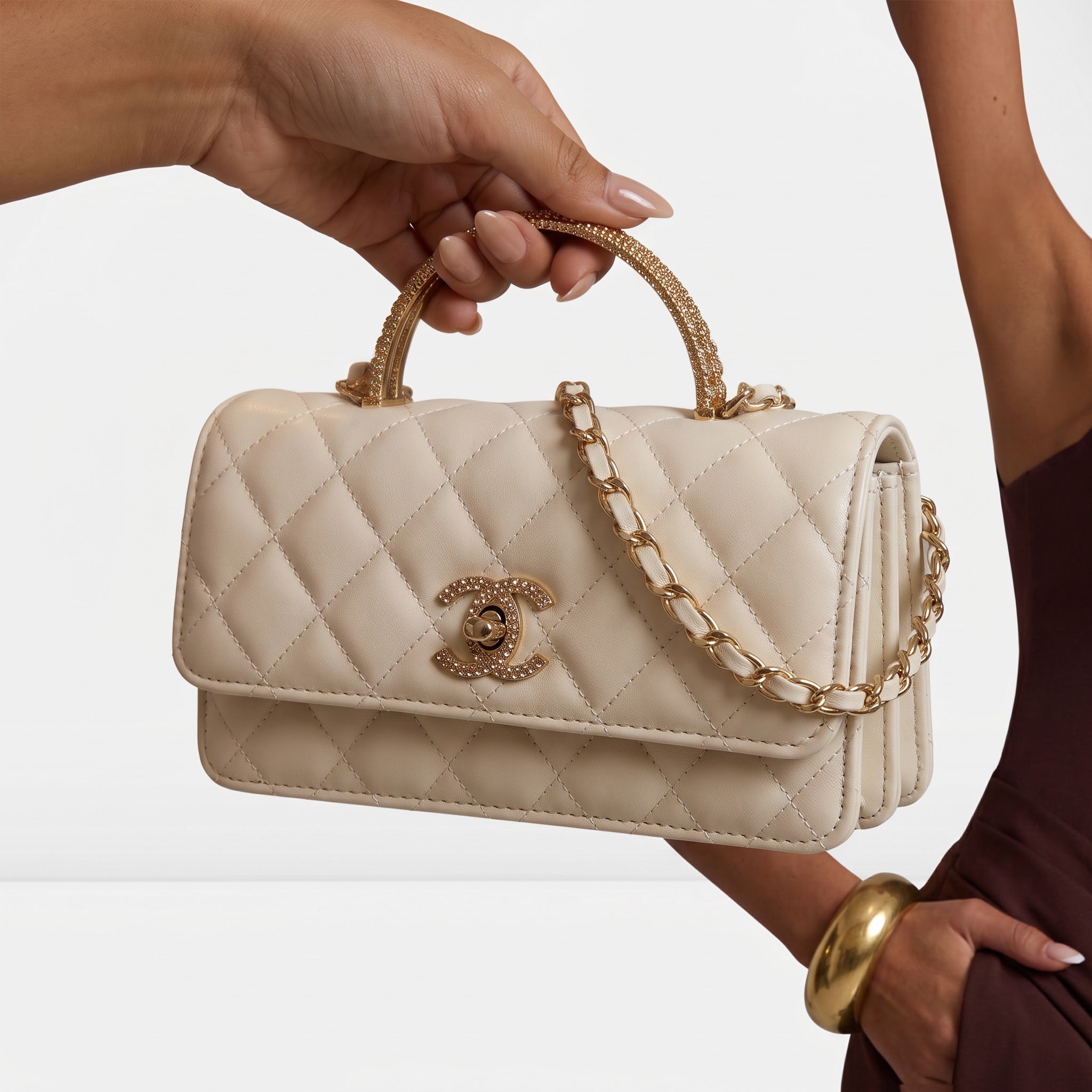 Cream quilted Chanel mini flap bag with gold crystal-accent handle and chain strap