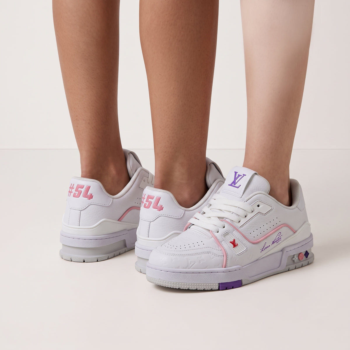 White Louis Vuitton low-top trainer with pink piping, purple sole accents and embossed monogram