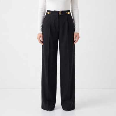 High-waist black wide-leg trousers with gold decorative hardware at the waist