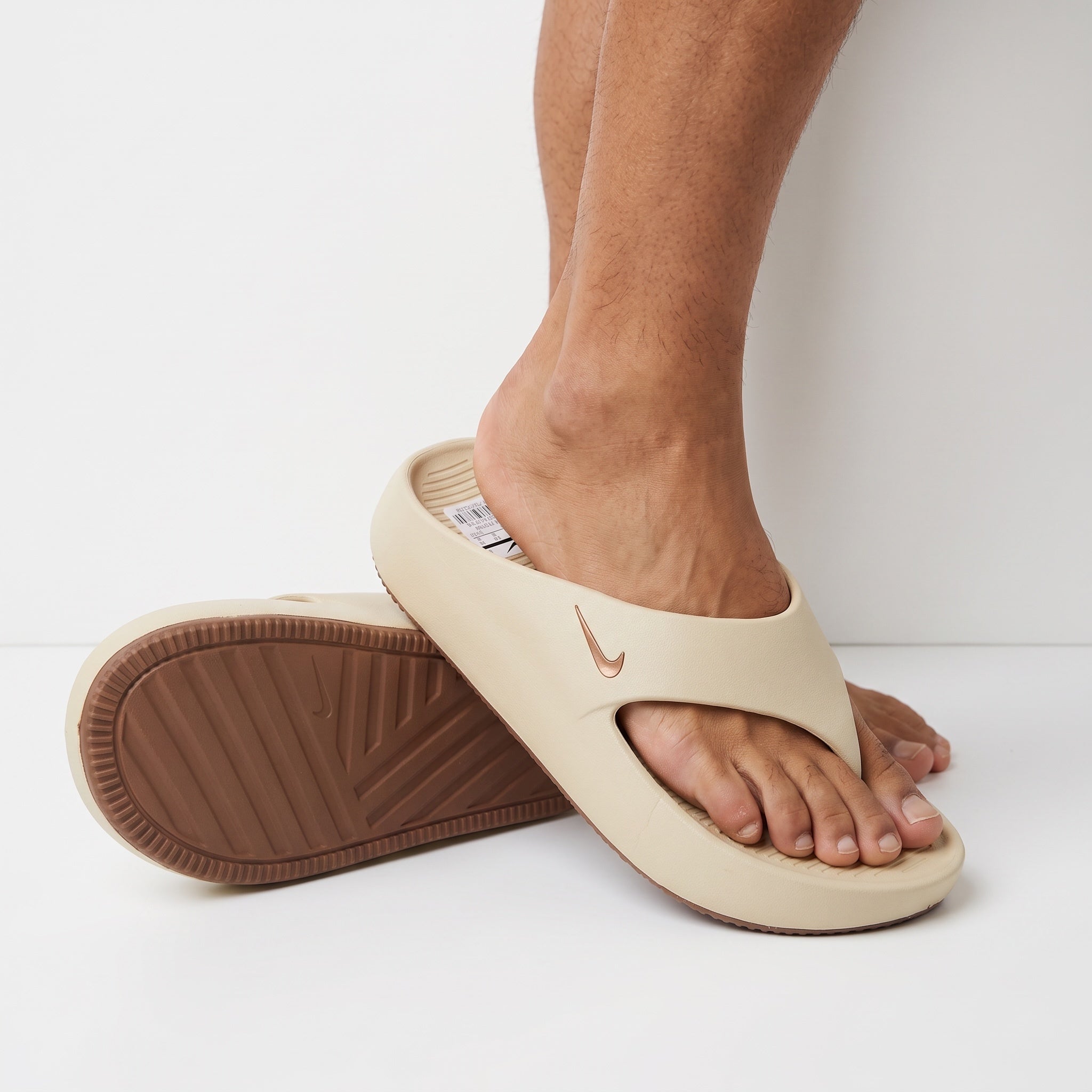 beige Nike foam slide with brown sole and metallic Swoosh