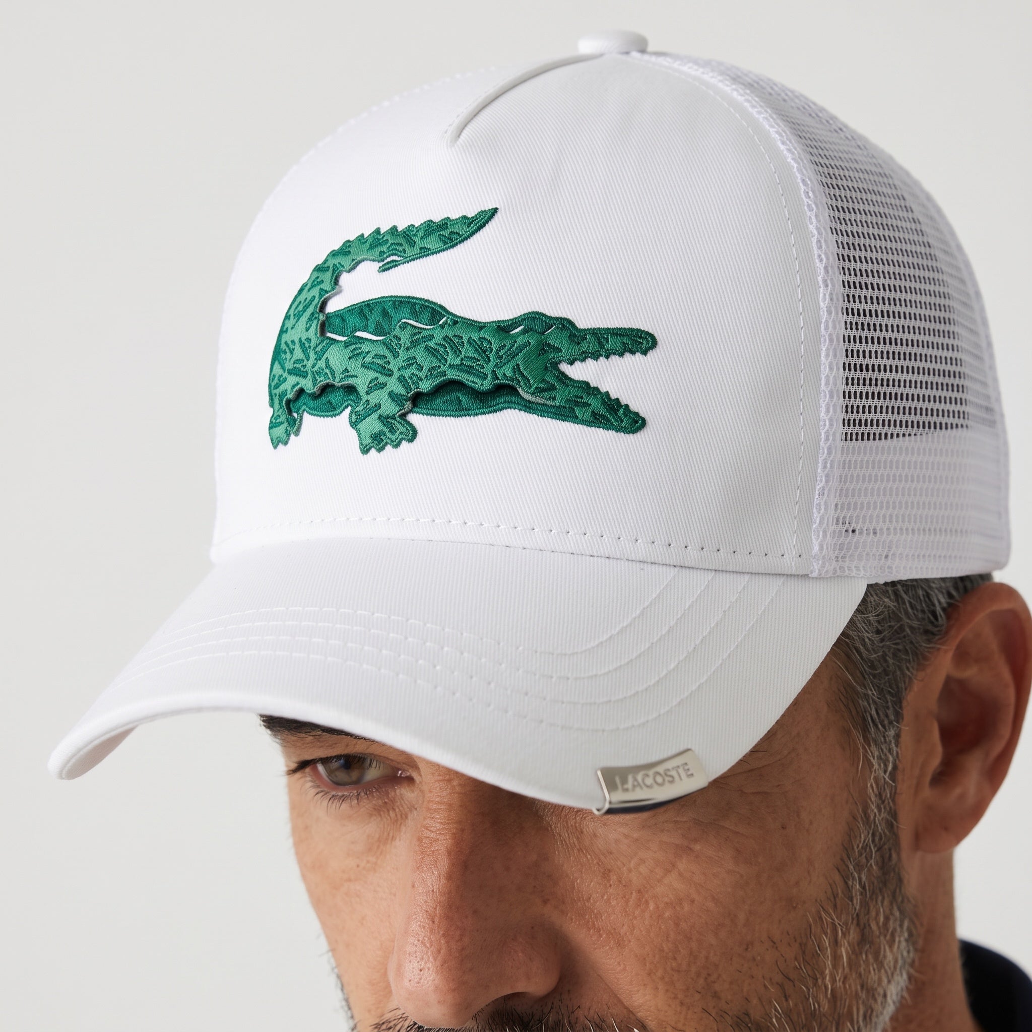 White Lacoste mesh trucker cap with large green crocodile logo embroidery
