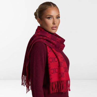Red Celine Triomphe jacquard scarf draped over shoulders with fringed ends