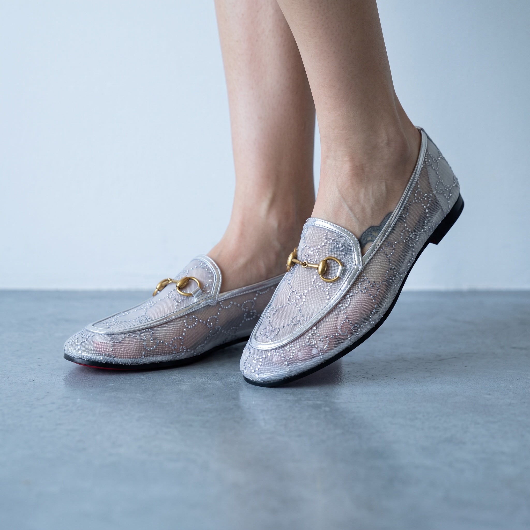 Silver Gucci mesh loafers with gold horsebit and red sole