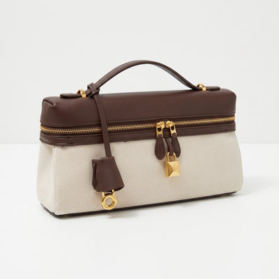 Beige canvas top-handle bag with brown leather trim and gold padlock hardware