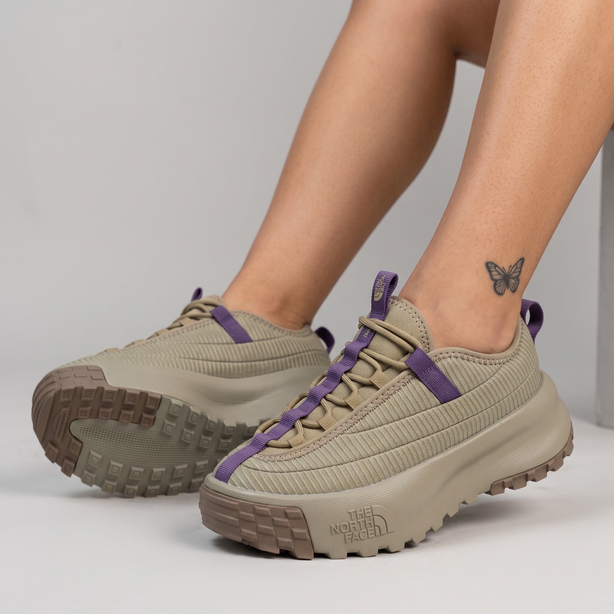 beige The North Face sneaker with purple webbing and chunky lug sole