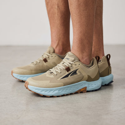 Altra tan trail running shoe with light blue midsole and Vibram sole