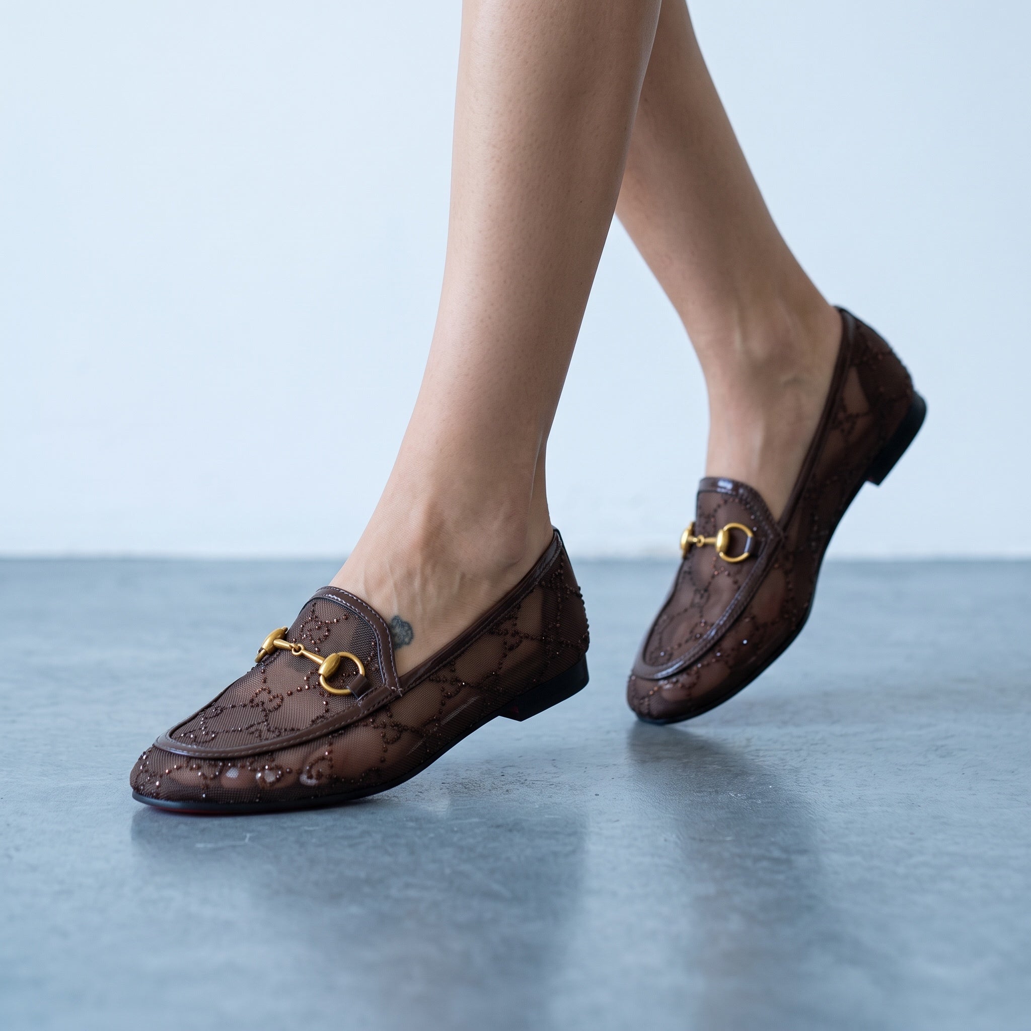 Brown Gucci mesh loafers with gold horsebit and red sole