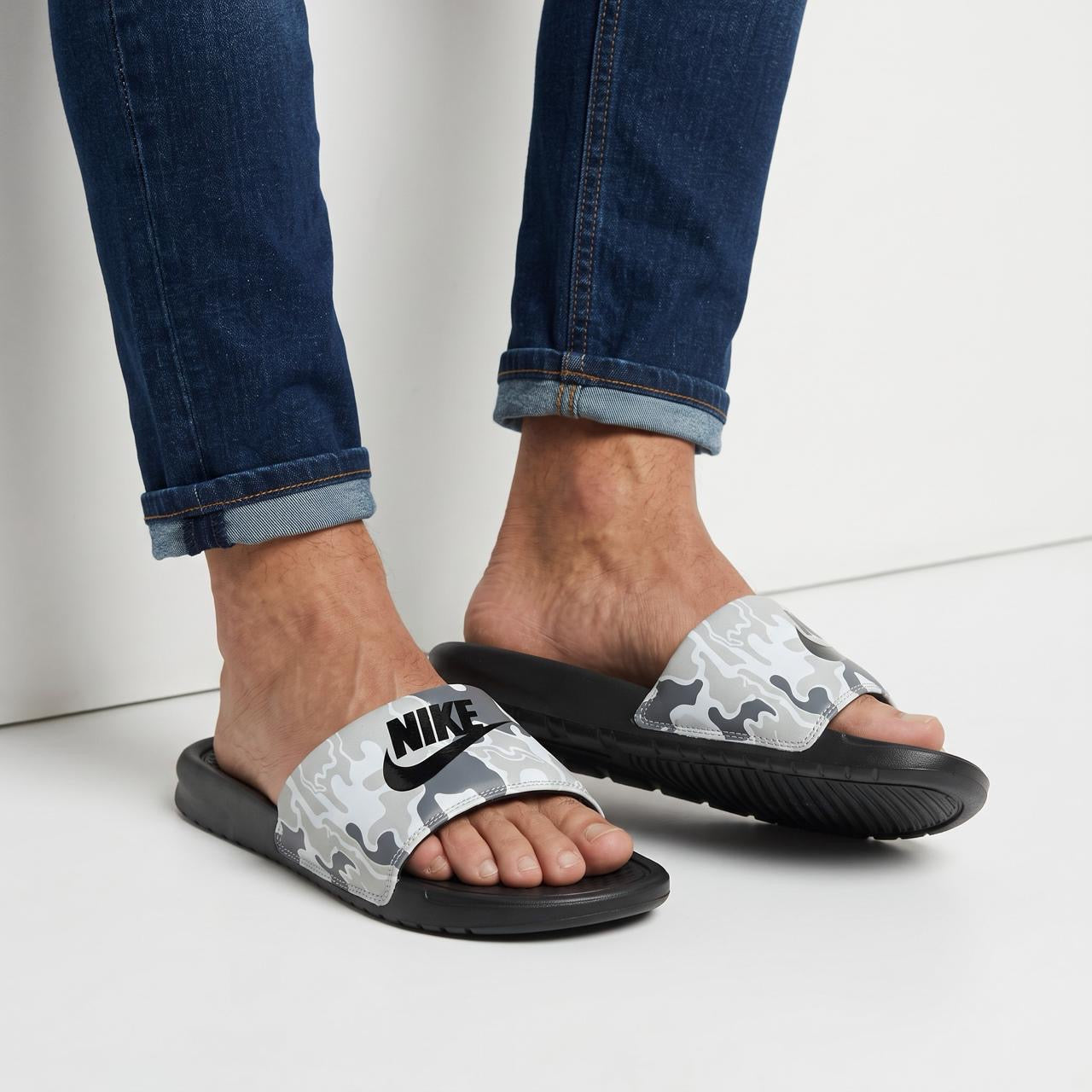 Nike grey camouflage slide sandals with black footbed and large black Nike logo