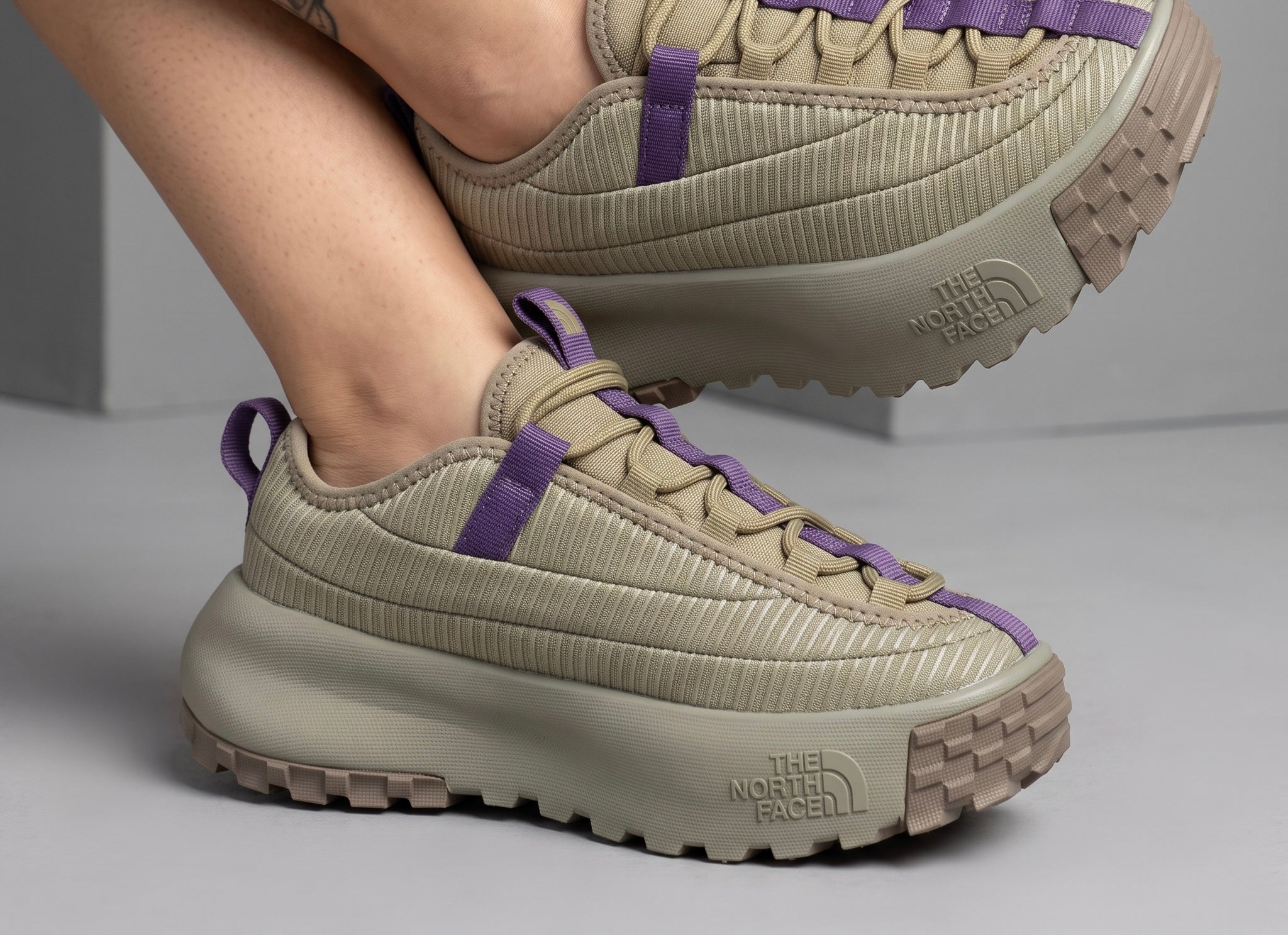 beige The North Face sneaker with purple webbing and chunky lug sole