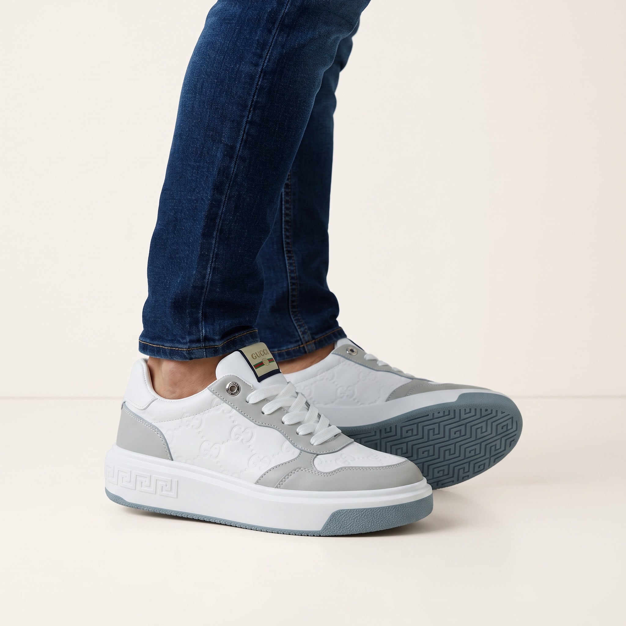 White and grey Gucci platform low-top sneaker with embossed GG and branded tongue