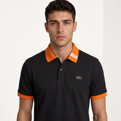 Black Hermès short-sleeve polo with orange collar and cuffs.