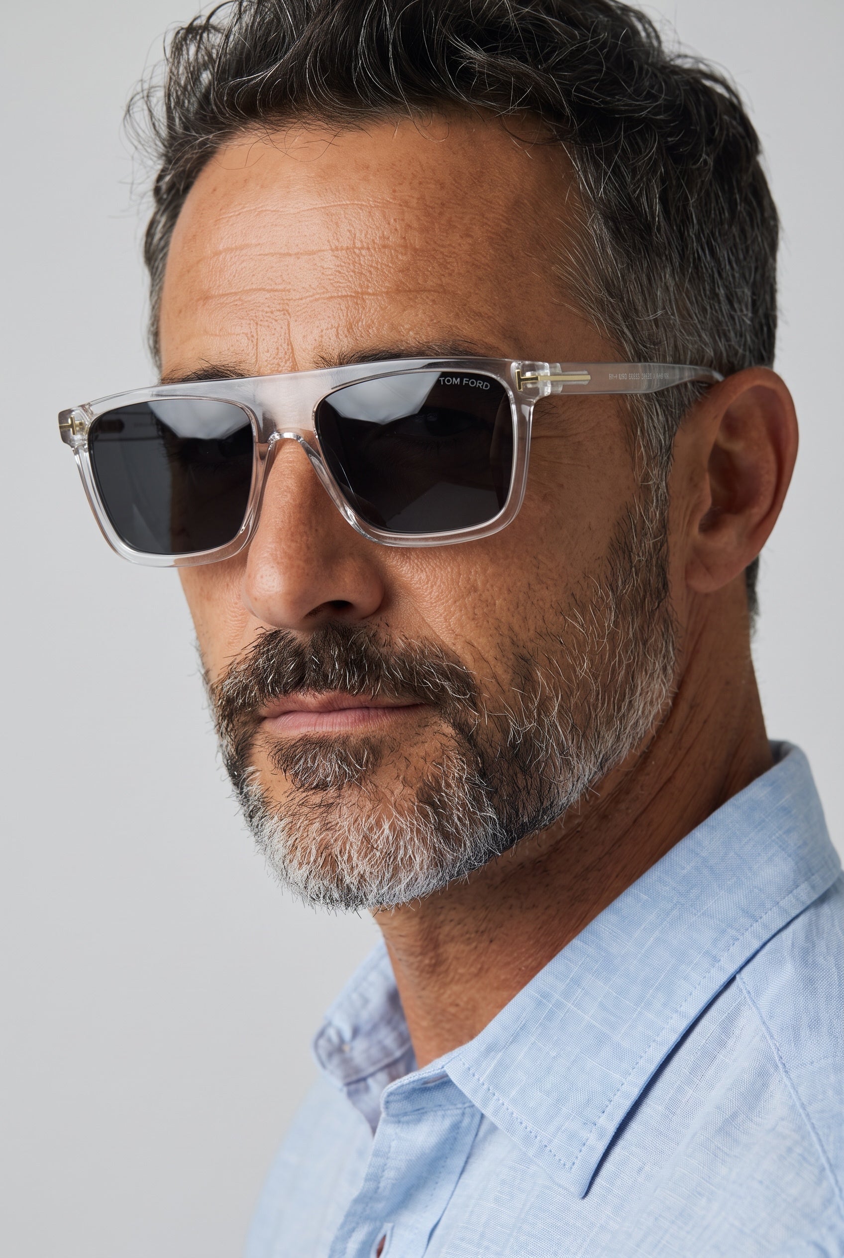 Tom Ford square clear frame sunglasses with dark lenses and gold T hinge on a model