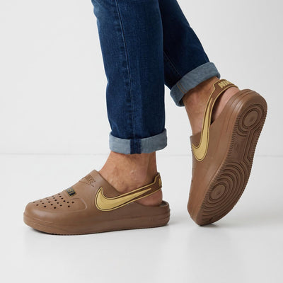 Brown Nike clog with gold swoosh and heel strap shown on model