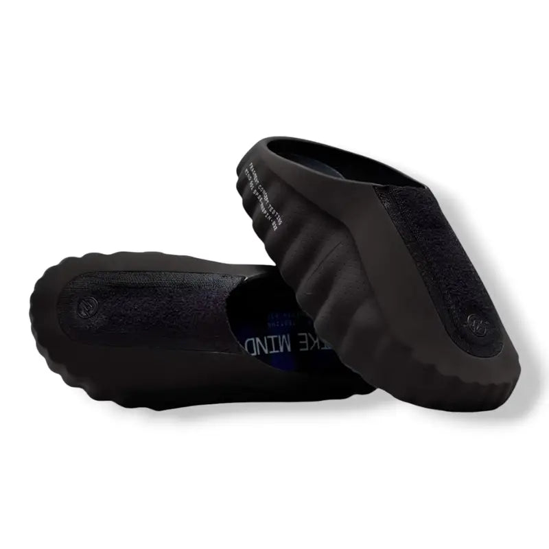 Black Nike Mind slip-on clog with blue circular pods on the sole