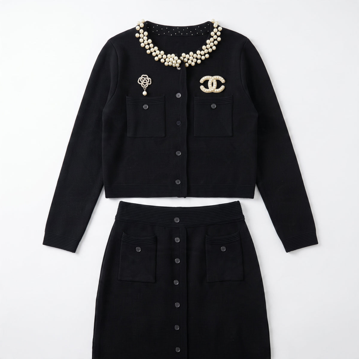 black Chanel cardigan with pearl collar and decorative brooches