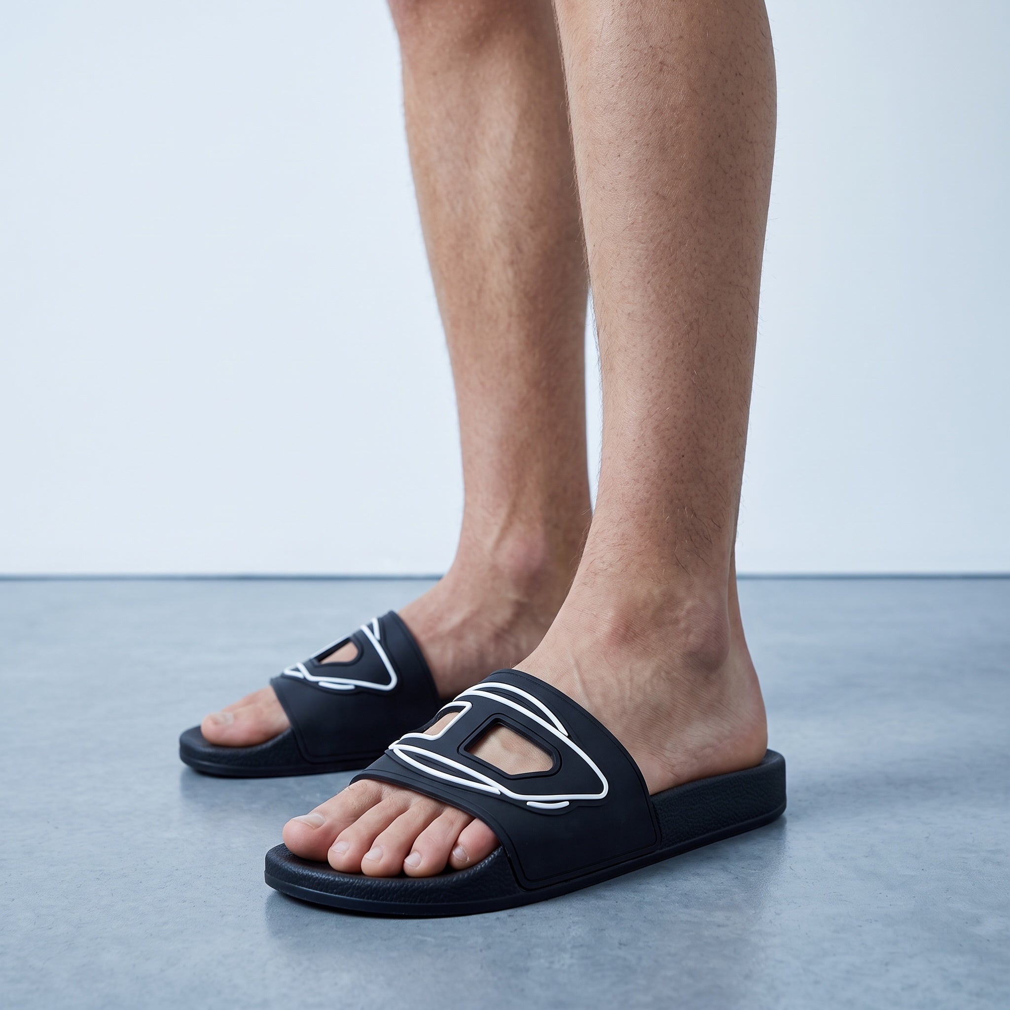 Black Oran-style slides with white trim and H cutout on feet