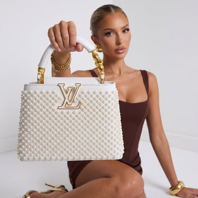White Louis Vuitton top-handle bag with pearl studs and gold LV logo