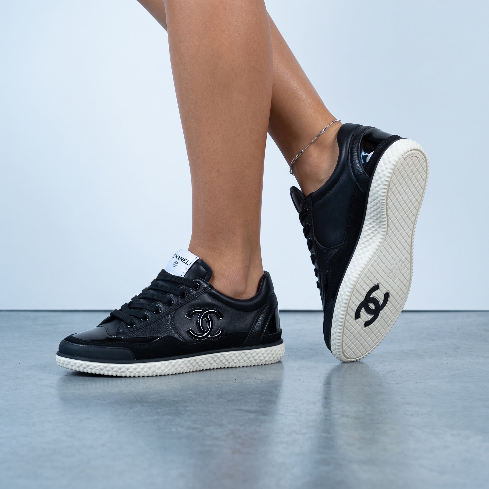 Chanel black low-top sneakers with white textured sole and CC logo