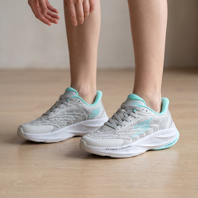 Light grey Skechers sneakers with aqua trim visible carbon infused and hyper burst markings