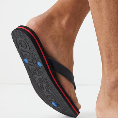 black flip flops with blue and red printed footbed and black straps reading QuickSurf