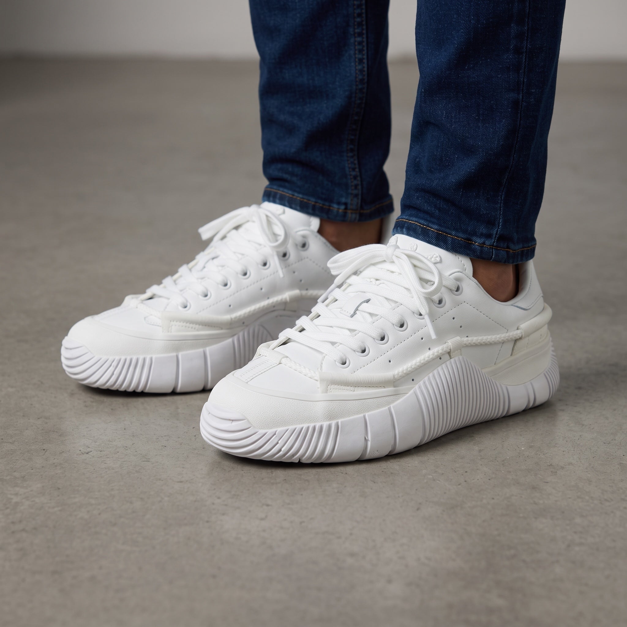 All-white Adidas Stan Smith low-top sneakers with chunky ribbed sole and rope detail