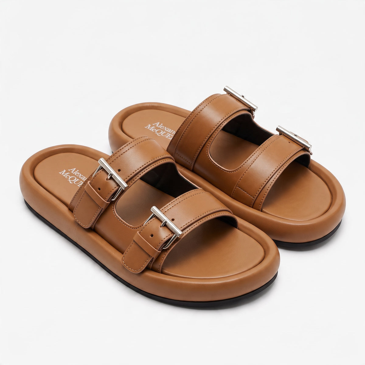 Alexander McQueen tan double-strap slide sandals with silver buckles and black rubber sole