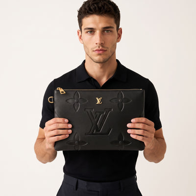 black Louis Vuitton embossed monogram clutch with gold zipper held by model