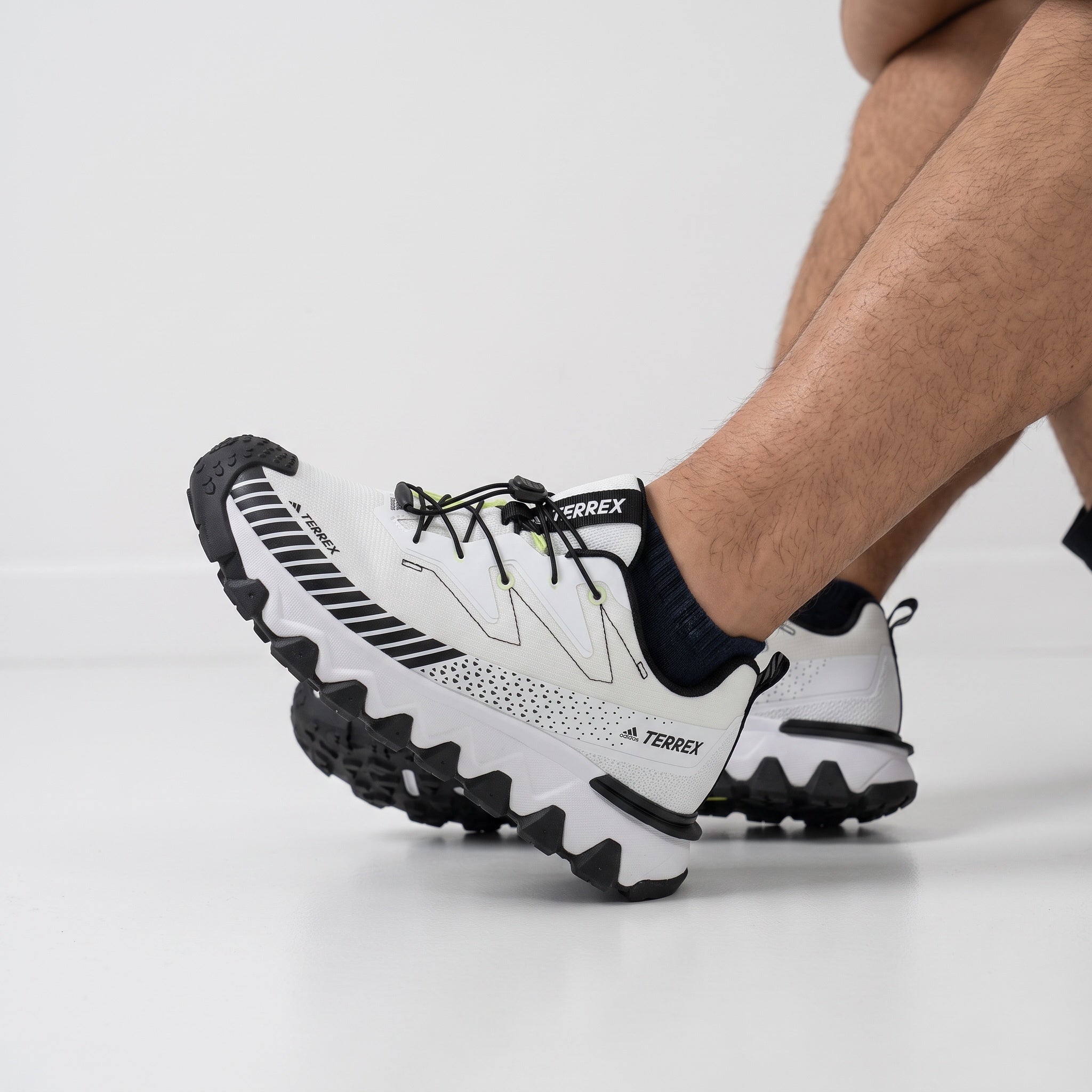 White Adidas Terrex trail running sneaker with black accents and lugged sole