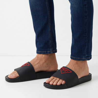 Black Prada rubber slides with red triangular logo on strap