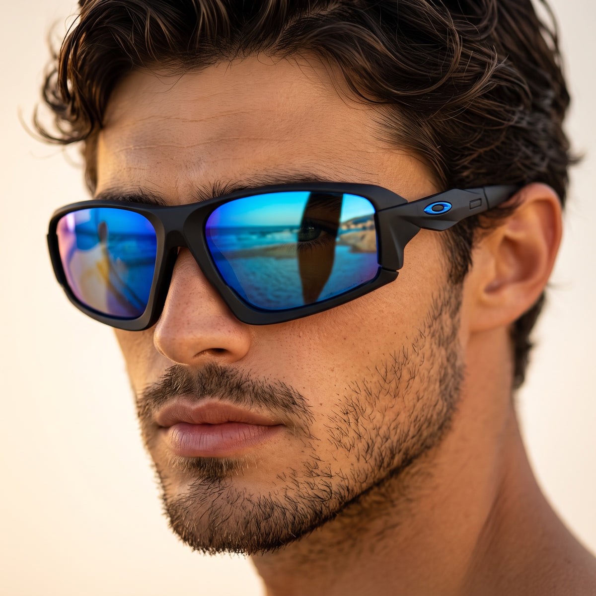 Oakley sunglasses with matte black frame and blue mirrored lenses shown on model