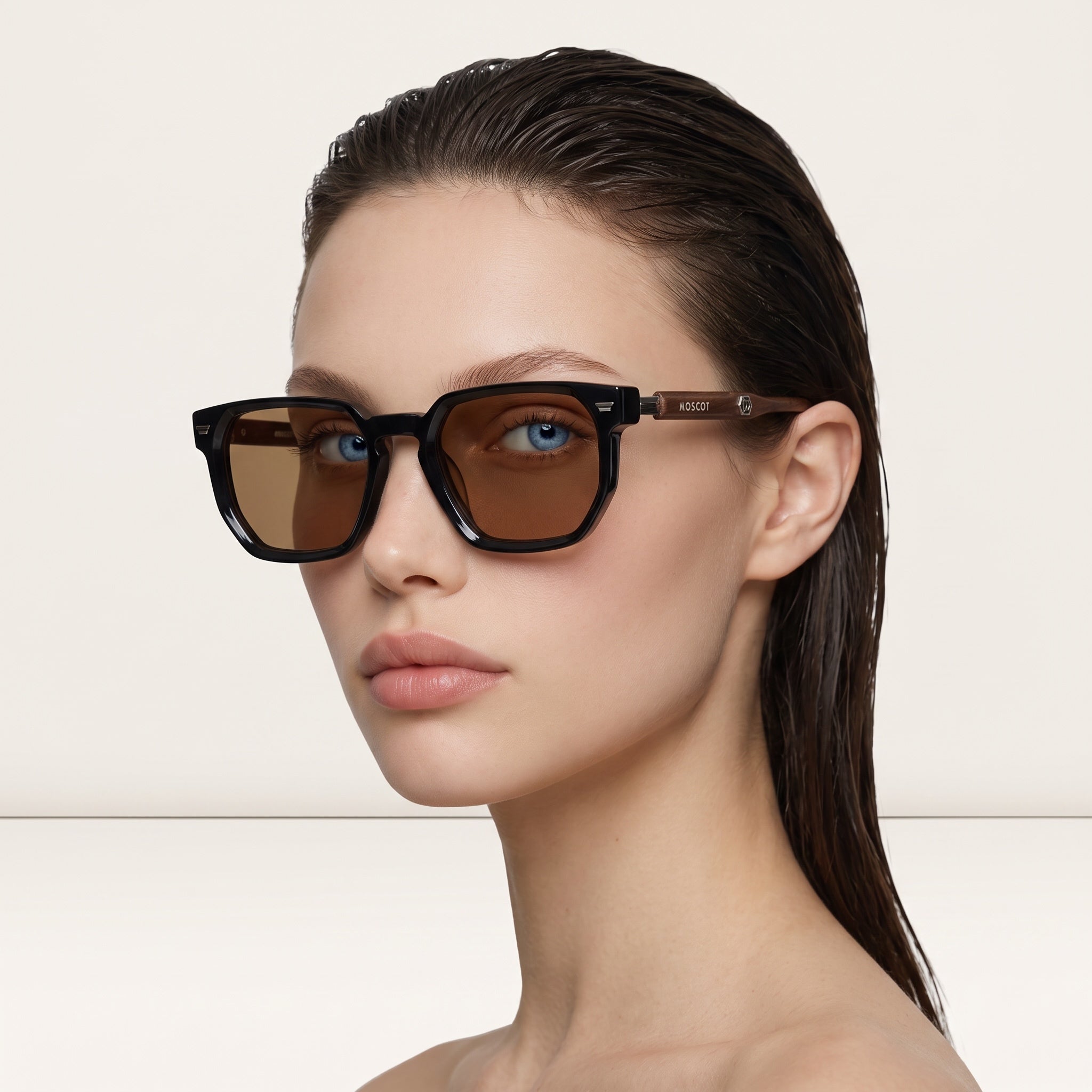 Moscot square sunglasses with black front and brown lenses showing MOSCOT logo on brown temples
