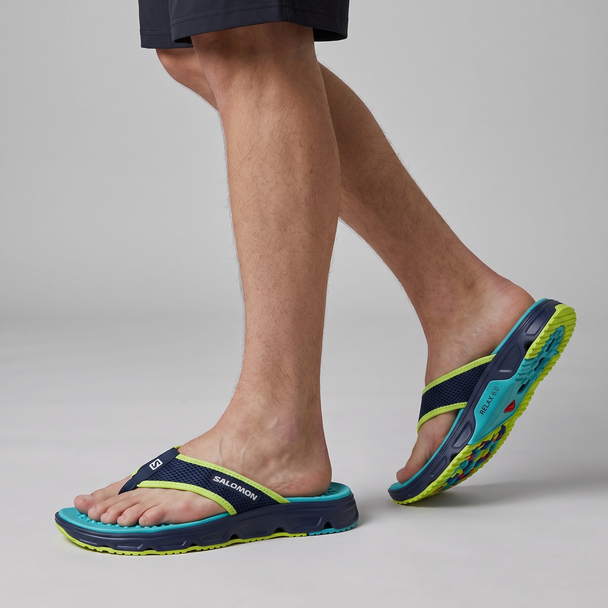 Salomon navy teal lime cushioned flip-flop viewed on model feet