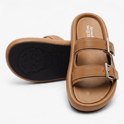 Alexander McQueen tan double-strap slide sandals with silver buckles and black rubber sole